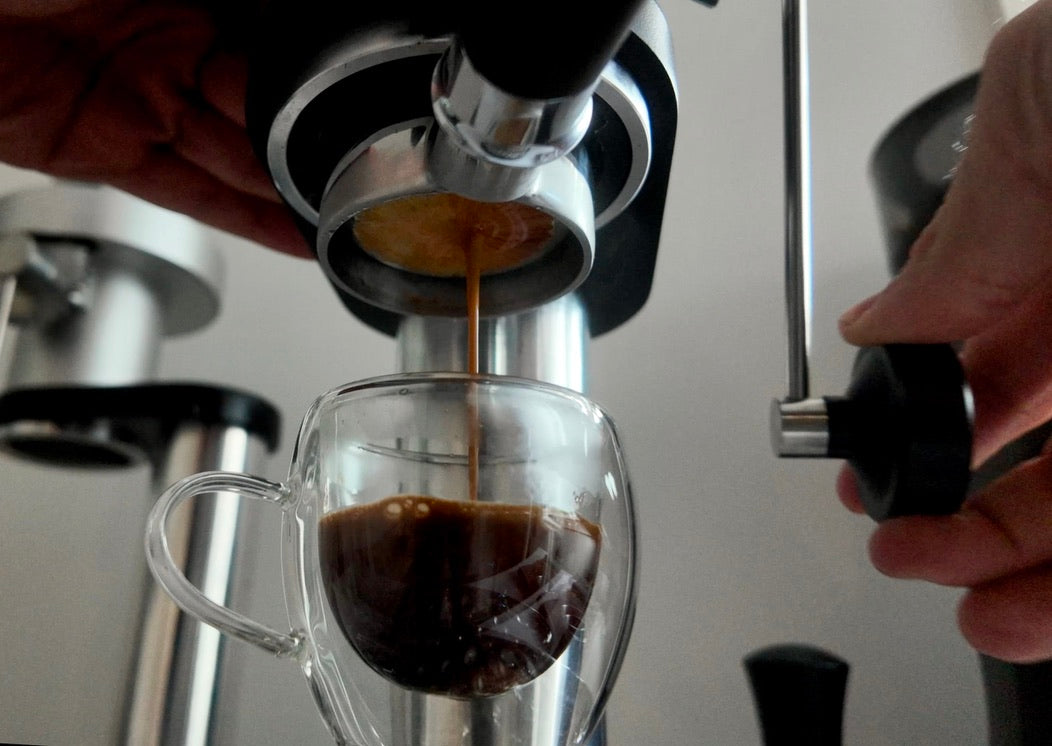 Espresso pouring into a glass cup